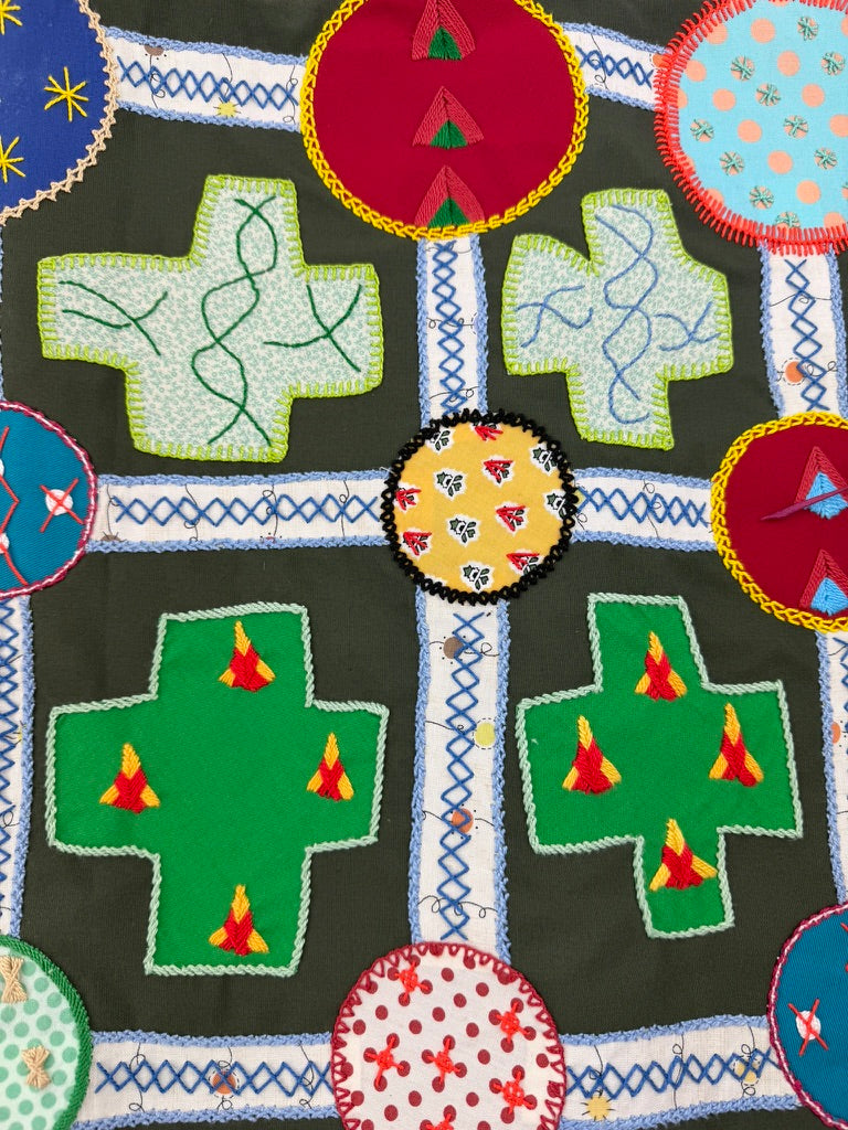 Cruces Design by Pamela Nelson. Hand Embroidered on dark green Pamela Nelson