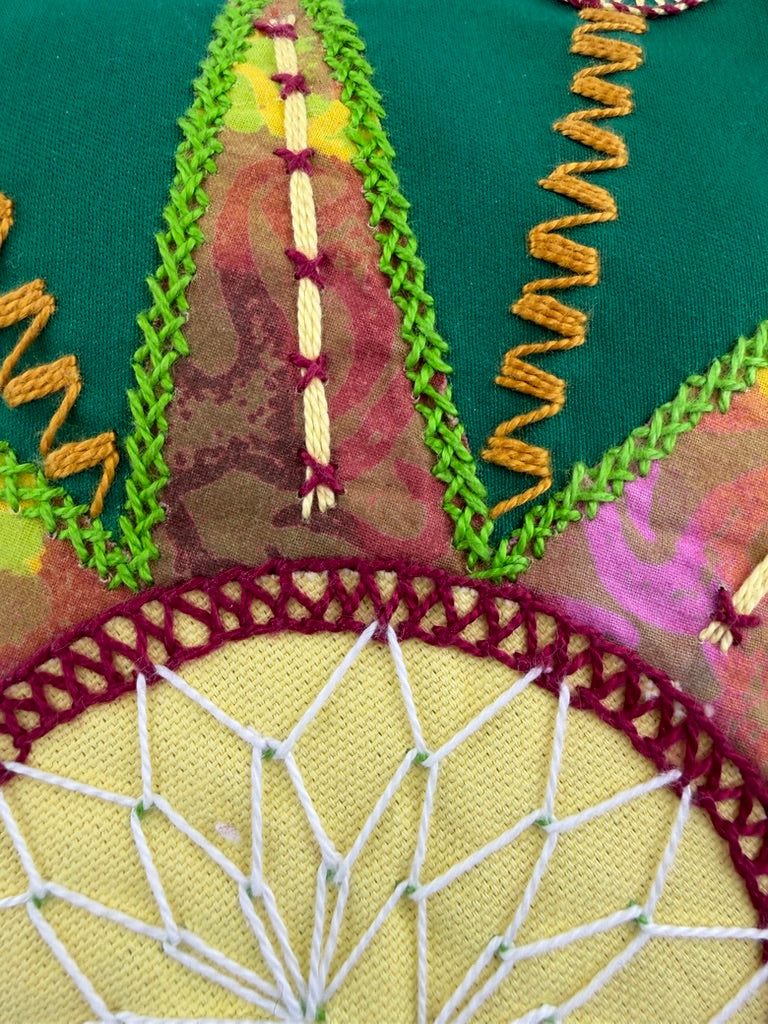 Sol Azul Design by Pamela Nelson. Hand Embroidered on green Honduras Threads