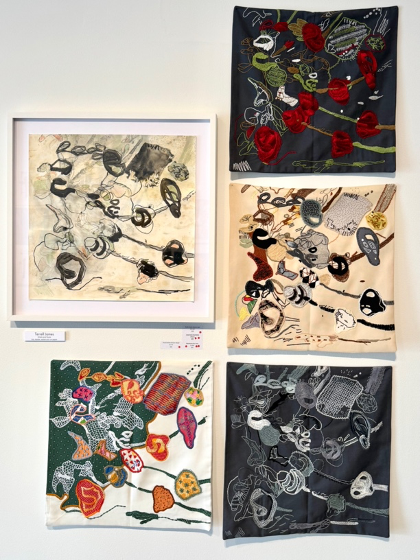 Collection of artistic fabric pieces displayed on a white wall