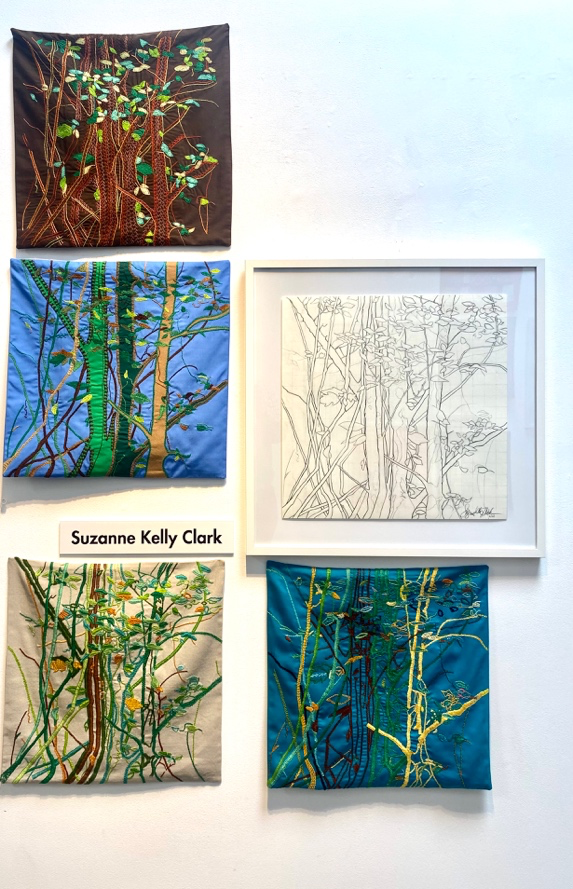 Collection of nature-themed artworks by Suzanne Kelly Clark on a white wall.