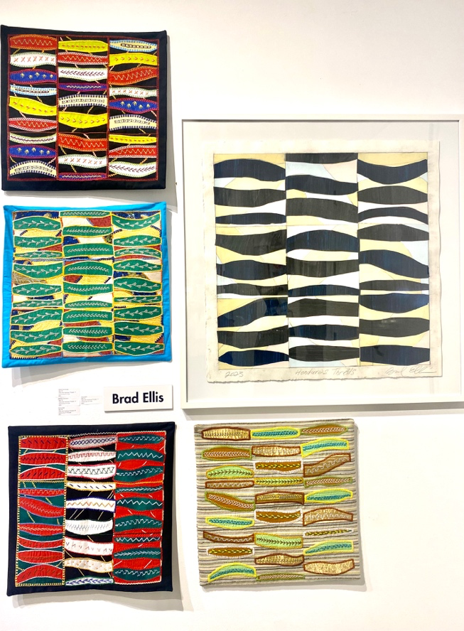 Collection of framed abstract artworks with wavy patterns on a white wall.